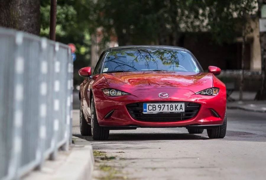 На живо Mazda MX-5 изглежда още по-малка, отколкото на снимките. Ако я съпоставите с предметите около нея, ще видите, че наистина е така. За да се насладите на красотата на автомобила е необходимо леко да се отдалечите и ще видите, как външният вид на колата ви провокира, при това във всички перспективи. 